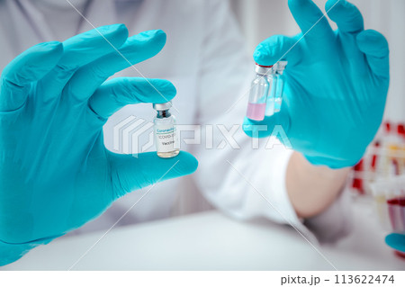 Researcher holding vaccine sample in the laboratory. Researcher is inventing vaccines to treat COVID-19 virus. 113622474