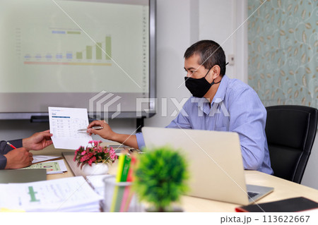 Businessmen wearing protective masks discussing and work together in meeting room. Social distance practice prevent coronavirus COVID-19. Businessmen wearing protective masks discussing and work together in meeting room. Social distance practice prevent coronavirus COVID-19. 113622667