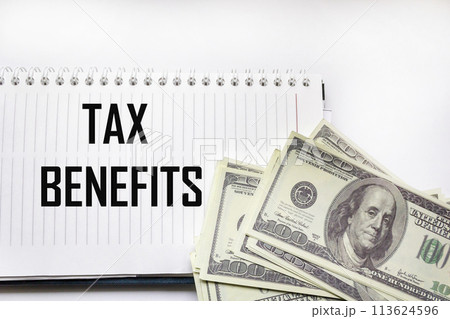 The word tax breaks on a notepad next to dollars. Business and taxation concept. The word tax breaks on a notepad next to dollars. Business and taxation concept. 113624596