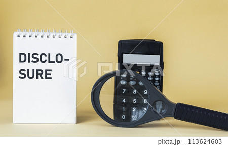 The word DISCLOSURE writing in a notepad. Magnifying glass and calculator on a yellow background The word DISCLOSURE writing in a notepad. Magnifying glass and calculator on a yellow background 113624603
