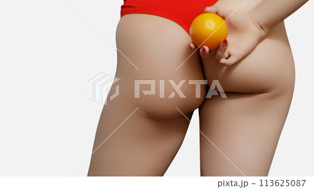 Young woman holding orange on light background 113625087