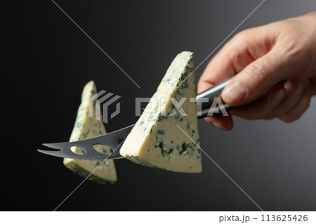 Cheese knife and piece of blue cheese. 113625426