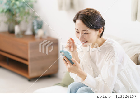 スマホを見て喜ぶ30代女性 スマホを見て喜ぶ30代女性 113626157