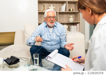 Female doctor examining older senior man in doctor office or at home. Old man patient and doctor have consultation in hospital room. Medicine healthcare medical checkup. Visit to doctor 113626359