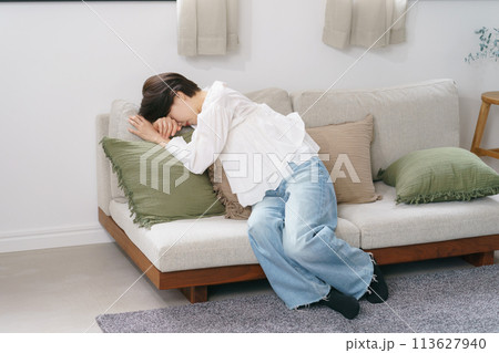 ソファにぐったりと倒れ込む女性 113627940