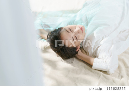 ベッドで横になる女性 113628235