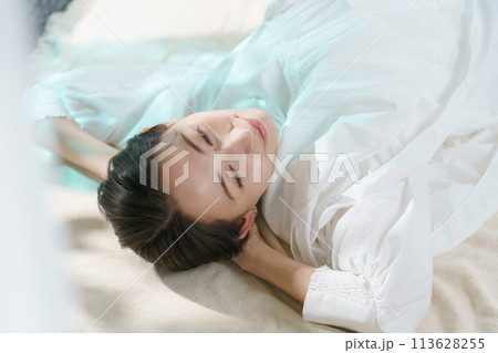 ベッドで横になる女性 113628255