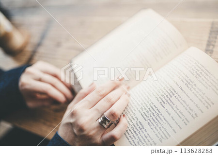 カフェで読書している人の手元 113628288