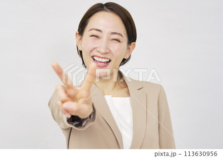 ピースサインをするビジネスウーマン 白背景 ピースサインをするビジネスウーマン 白背景 113630956