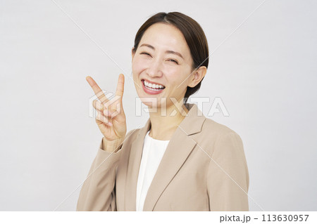 ピースサインをするビジネスウーマン　白背景 113630957