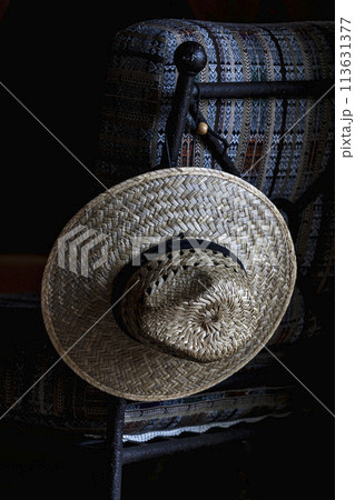 Straw hat hanging on chair Straw hat hanging on chair 113631377