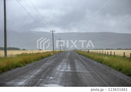 Rain clouds over dirt road in summer 113631881
