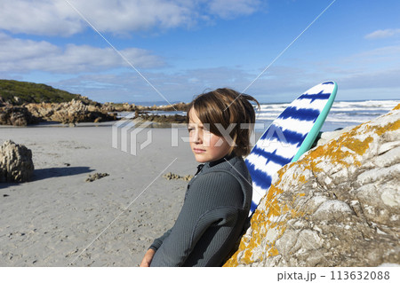Boy (10-11) with body board relaxing on Voelklip Beach 113632088