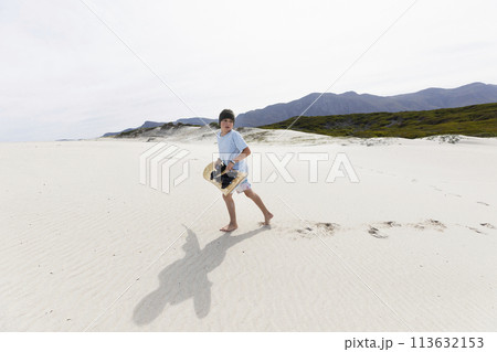Boy (10-11) carrying surfboard in Walker Bay Nature Reserve Boy (10-11) carrying surfboard in Walker Bay Nature Reserve 113632153