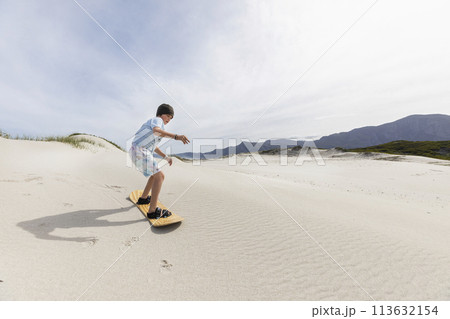 Boy (10-11) sand boarding in Walker Bay Nature Reserve Boy (10-11) sand boarding in Walker Bay Nature Reserve 113632154