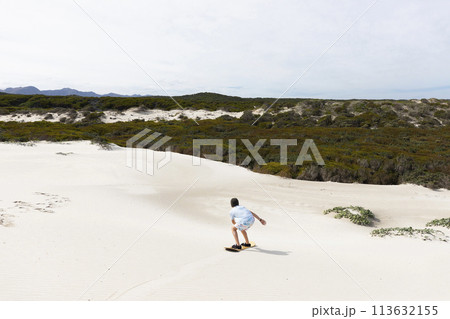 Boy (10-11) sand boarding in Walker Bay Nature Reserve Boy (10-11) sand boarding in Walker Bay Nature Reserve 113632155