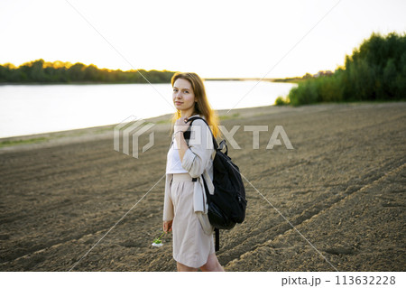 Portrait of thoughtful woman standing on beach at sunset Portrait of thoughtful woman standing on beach at sunset 113632228