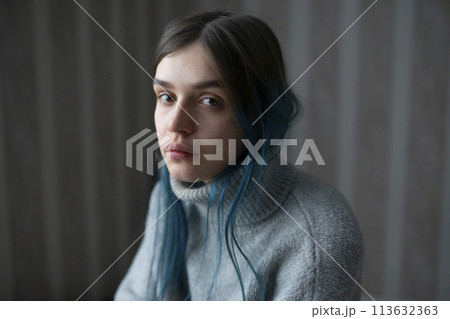 Portrait of serious woman in gray sweater 113632363