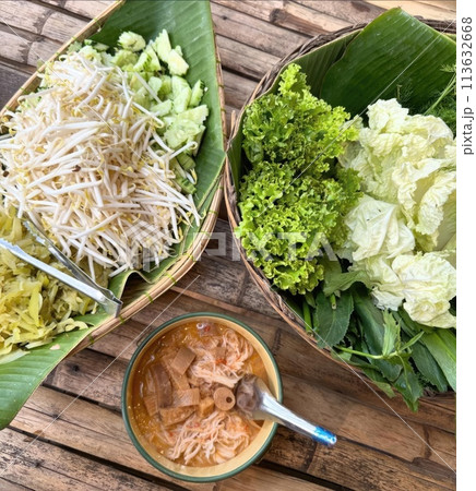 Fresh and healthy Thai food with garden vegetables on a wooden table Fresh and healthy Thai food with garden vegetables on a wooden table 113632668