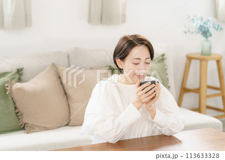 リビングでコーヒーを飲む女性 リビングでコーヒーを飲む女性 113633328