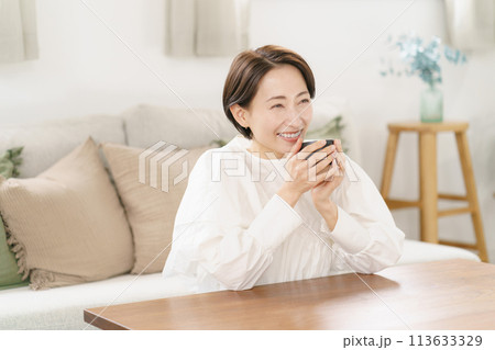 リビングでコーヒーを飲む女性 リビングでコーヒーを飲む女性 113633329