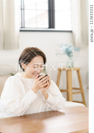 リビングでコーヒーを飲む女性 113633331