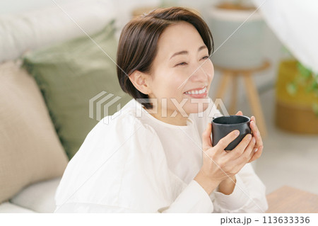 リビングでコーヒーを飲む女性 リビングでコーヒーを飲む女性 113633336