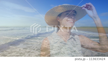 Caucasian woman in a hat walks on the beach 113633424