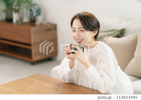 リビングでコーヒーを飲む女性 113633495