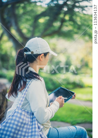 緑豊かなアメリカの大学のキャンパスで学ぶ学生 113634137