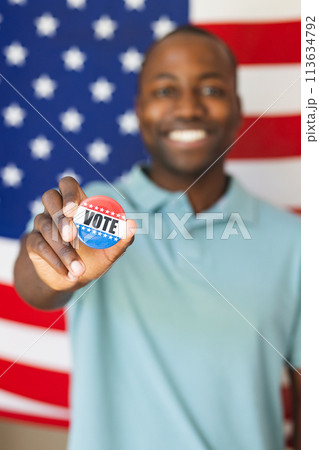 Young African American man shows a 'vote' badge proudly, with copy space Young African American man shows a 'vote' badge proudly, with copy space 113634792