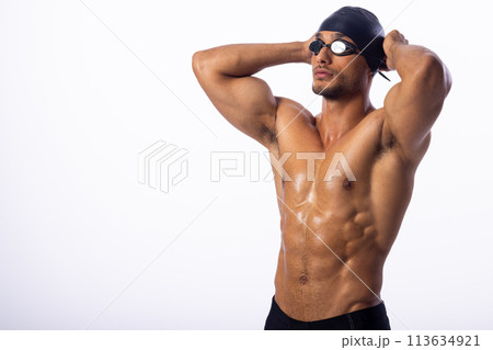 Athletic young biracial male swimmer poses confidently Athletic young biracial male swimmer poses confidently 113634921