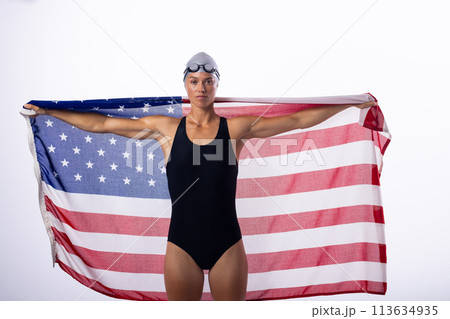 Female swimmer in a swimsuit holds an American flag Female swimmer in a swimsuit holds an American flag 113634935