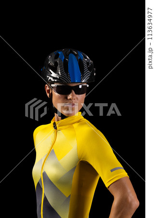 Young Caucasian female cyclist dressed in cycling gear poses confidently Young Caucasian female cyclist dressed in cycling gear poses confidently 113634977