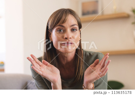 A middle-aged Caucasian woman gestures on a video call A middle-aged Caucasian woman gestures on a video call 113635178