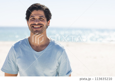Young biracial man smiles brightly at the beach 113635210