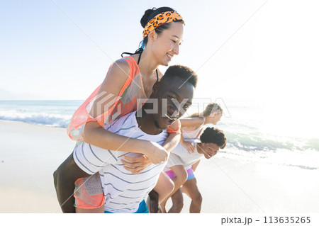Diverse group enjoys a piggyback ride on the beach, with copy space Diverse group enjoys a piggyback ride on the beach, with copy space 113635265