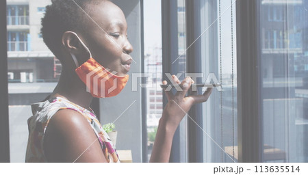 Image of financial data processing over businesswoman with face mask using smartphone in office 113635514