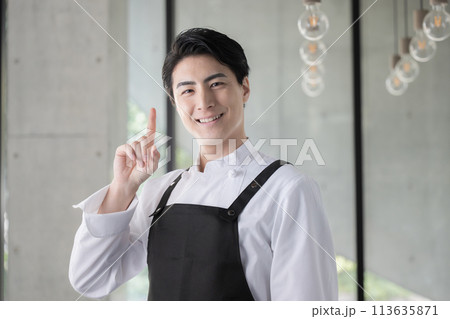 エプロンを着たシェフや飲食業で働く男性のイメージ　指さしのポイント　転職や採用にも 113635871