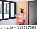 Professional women home Inspector surveyor wearing vests and hard hat at new property 113637365