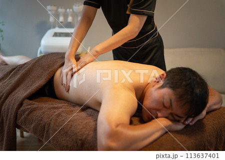 メンズエステサロンで痩身エステをする男性とエステティシャン・セラピスト メンズエステサロンで痩身エステをする男性とエステティシャン・セラピスト 113637401