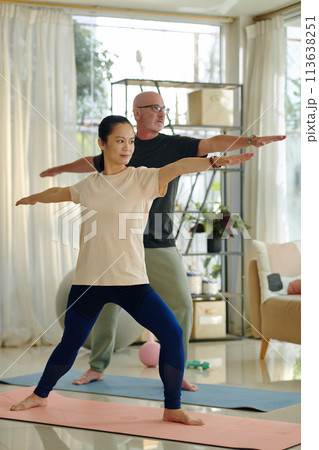 Active diverse couple practicing yoga at home 113638251