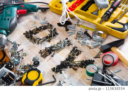 DIY abbreviation composed of screws and self-tapping screws, surrounded by various construction tools DIY abbreviation composed of screws and self-tapping screws, surrounded by various construction tools 113638554