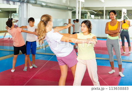 Group of kids training self-defence moves in gym 113638883