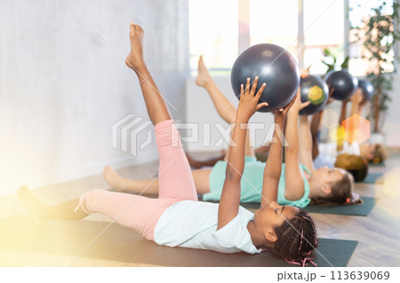 Kids doing pilates with softball 113639069
