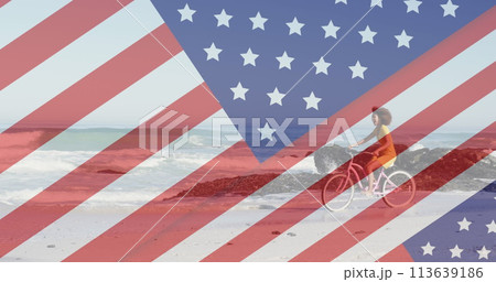 Image of american flag revealing statue of liberty and woman riding bike on beach 113639186