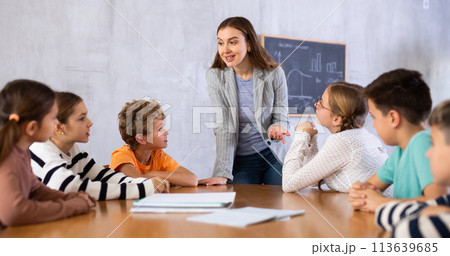 Portrait of female teacher giving lesson to children in school class 113639685