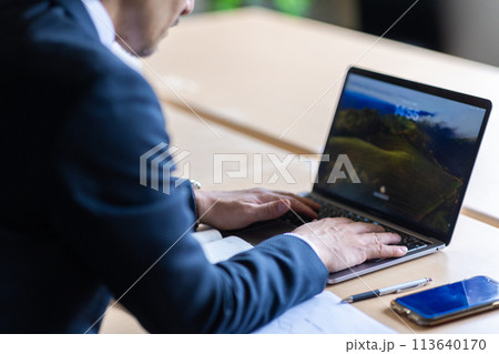 仕事をする男性の後ろ姿 113640170