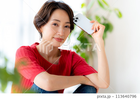 部屋でスマホを操作するミドル女性 部屋でスマホを操作するミドル女性 113640796