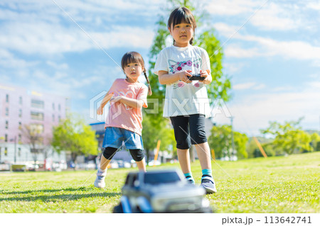 芝生の公園でラジコンで遊ぶ子ども 113642741